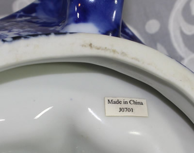 Label on the base of a white flowers on dark blue chintz loop handle juicer