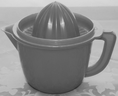 An open green plastic juicer on jug with lid