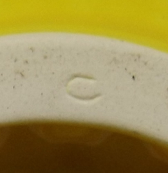 Insised mark on the base of a yellow ceramic saucer short pip collector juicer