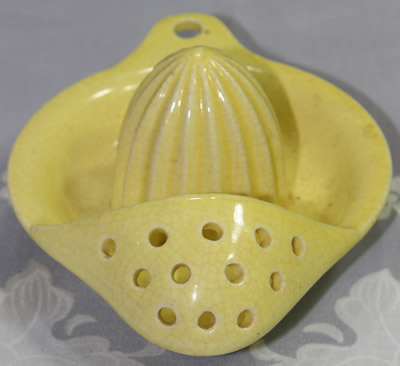 The front view of a yellow 12 hole Japanese strainer juicer