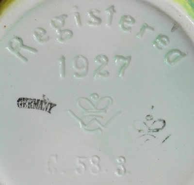 The basemark on an yellow, green leaves and brown handle ceramic juicer