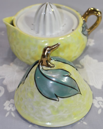 An open silver leaves on pale yellow lustre pear shape juicer