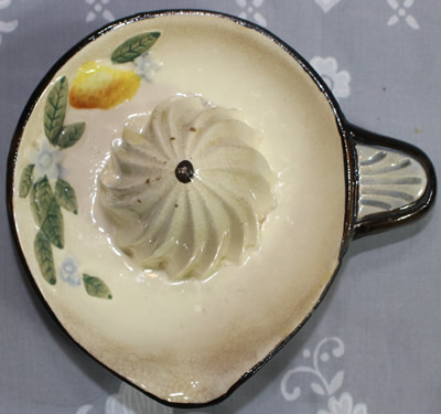 Top view of a blue & white with a lemon and flowers black trim ceramic juicer
