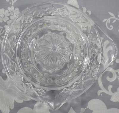 Top view of a diamond shapes on a large tab handle clear glass juicer