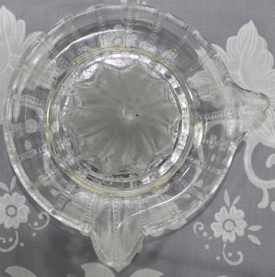 A 1 piece clear glass juicer with vertical lines of small squares top view