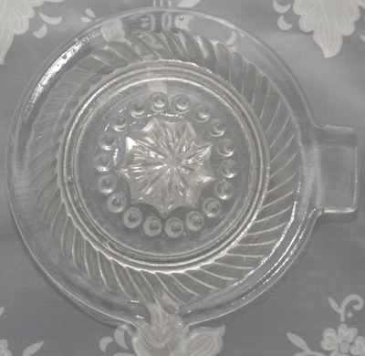 Top view of a sloping ribs clear and flat rim glass saucer juicer