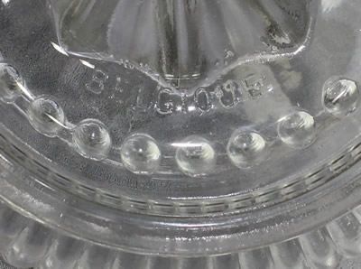 The embossed "BELGIQUE" on a clear glass offset tab handle juicer