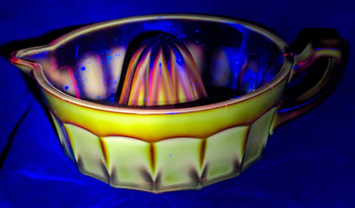 Large reproduction red carnival glass juicer under UV light