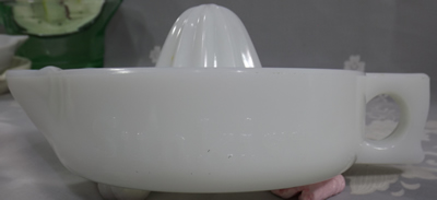 Side view of a curved handle SUNKIST white milk glass juicer