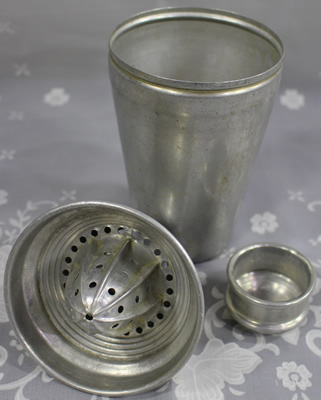Parts of a 3 piece aluminium cocktail shaker with a juicer