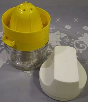 Open yellow and white 3 piece Gemco plastic juicer on glass jar
