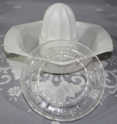 Two parts of a Made in Hong Kong white with clear stainer plastic juicer