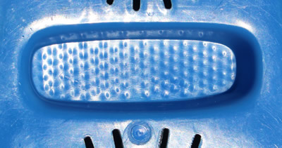 Unmarked bottom of zester of a dark blue plastic twin dome strainer juicer