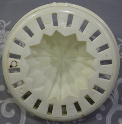 Bottom showing the notches on a reamer for a yellow-orange and white plastic juicer