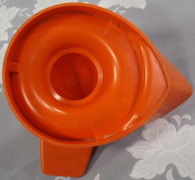 Bottom of red hard plastic right handed juicer showing original colour