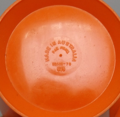 The jug base of a red and white HOSTESS plastic juicer