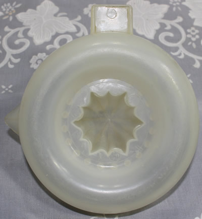 The base of a translucent white plastic juicer