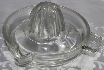 A 5&frac12;" Federal Glass Co. clear glass juicer